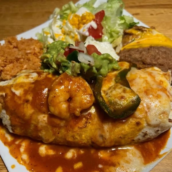 Kico's Mexican Food shrimp burrito with red sauce, rice, beans, guacamole, and salad.